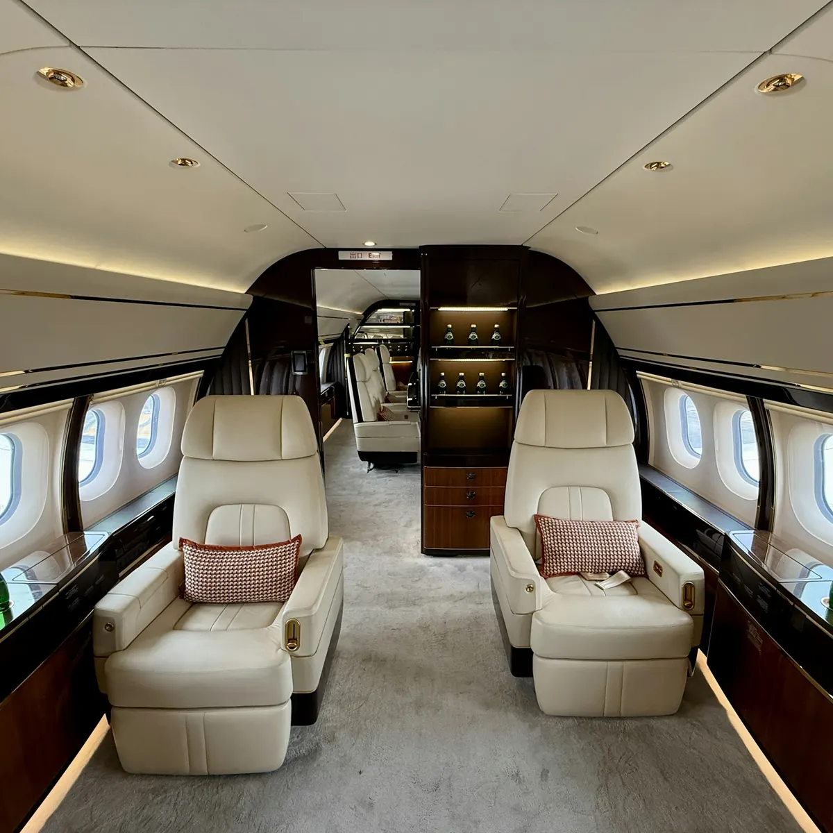 A wide cabin with cream seats on either side of the aisle